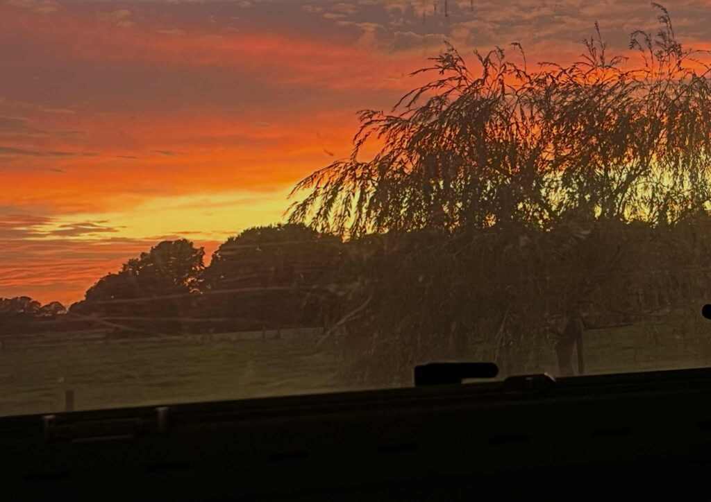 Sunset with bright orange and yellow colours. Photo taken from inside the campervan while slow travelling in The Netherlands